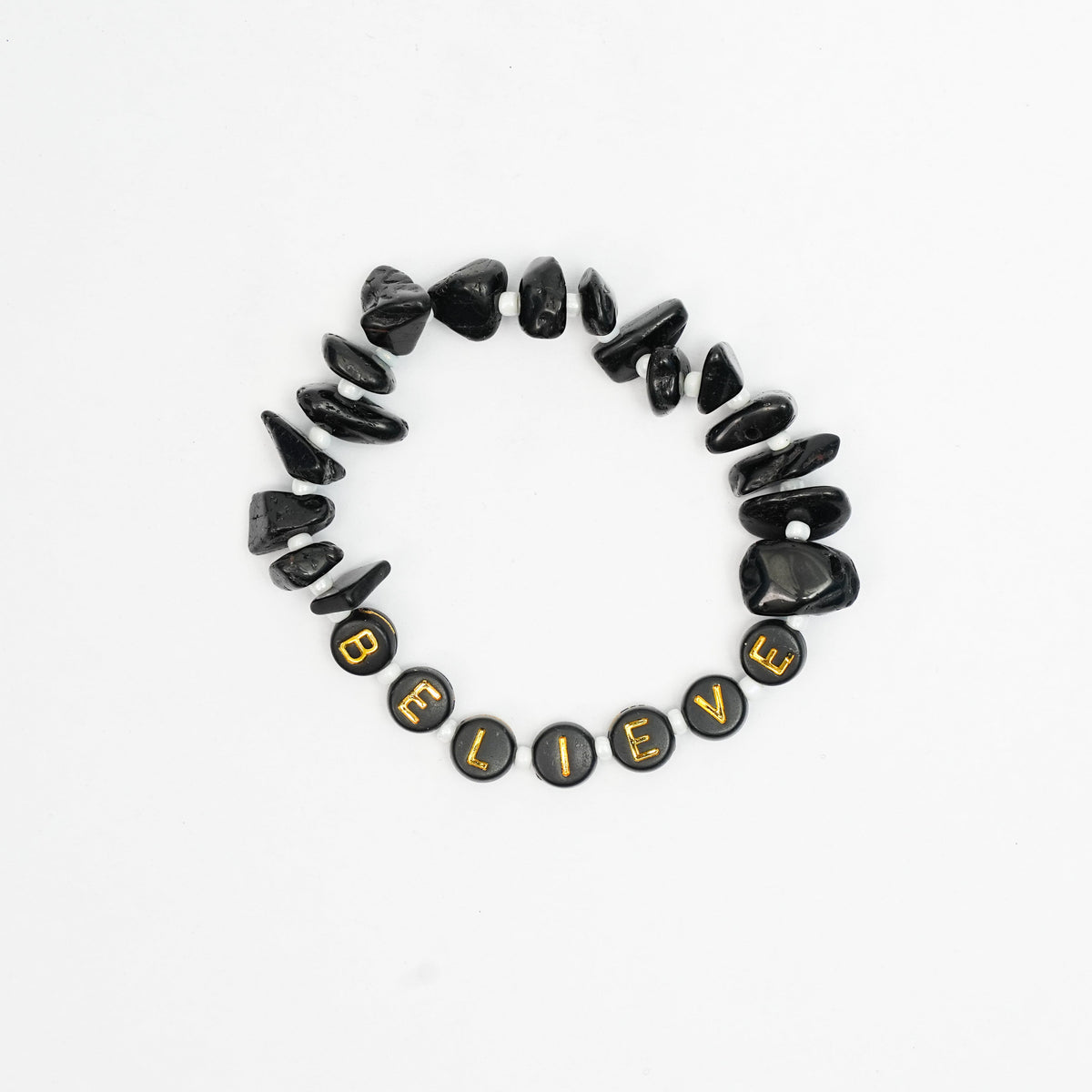 Black stone bracelet with 'BELIEVE' beads on a white background